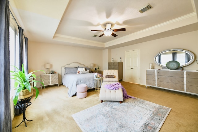 bedroom with a closet, ceiling fan, a raised ceiling, and carpet flooring