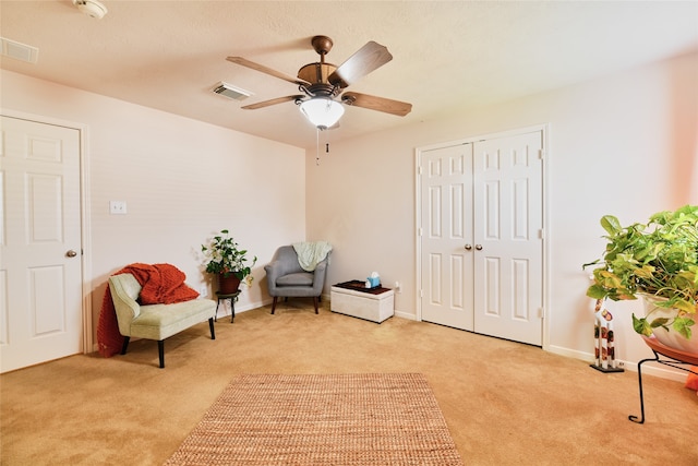 living area with ceiling fan and light colored carpet