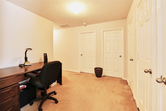 home office featuring baseboards, light carpet, a textured ceiling, and visible vents