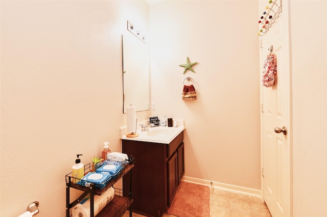 bathroom with baseboards, tile patterned flooring, and vanity