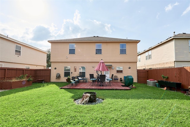rear view of property featuring a fenced backyard, a wooden deck, and a yard