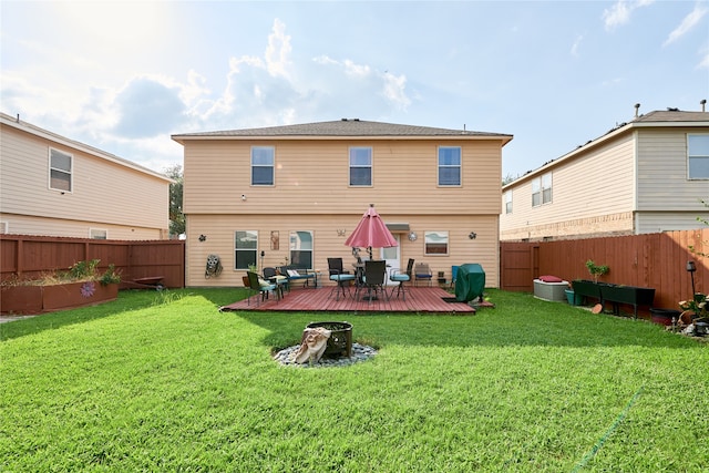 rear view of property with a deck and a yard