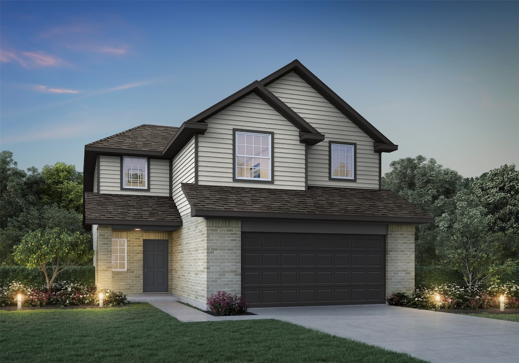 view of front property featuring a garage and a yard