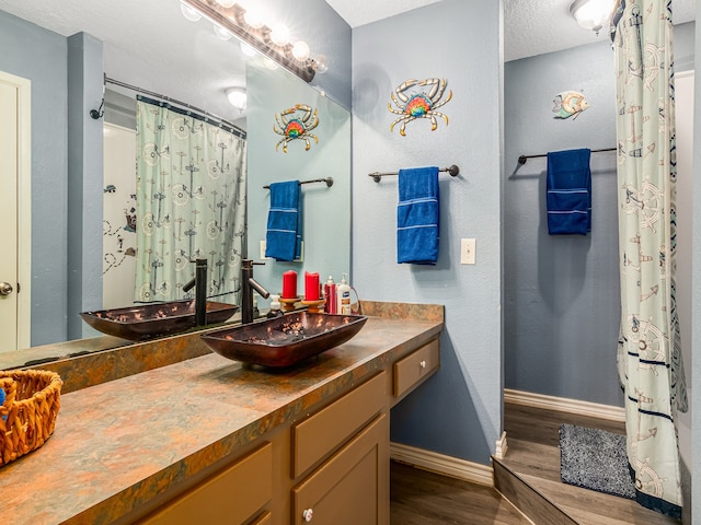 bathroom with vanity, a textured ceiling, and hardwood / wood-style flooring