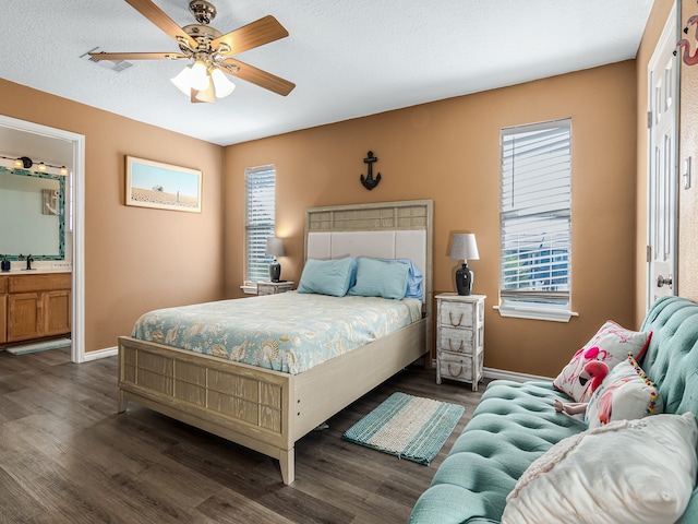 bedroom featuring ceiling fan, multiple windows, and dark hardwood / wood-style flooring