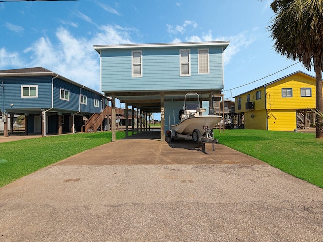 view of front of home with a front yard and a carport