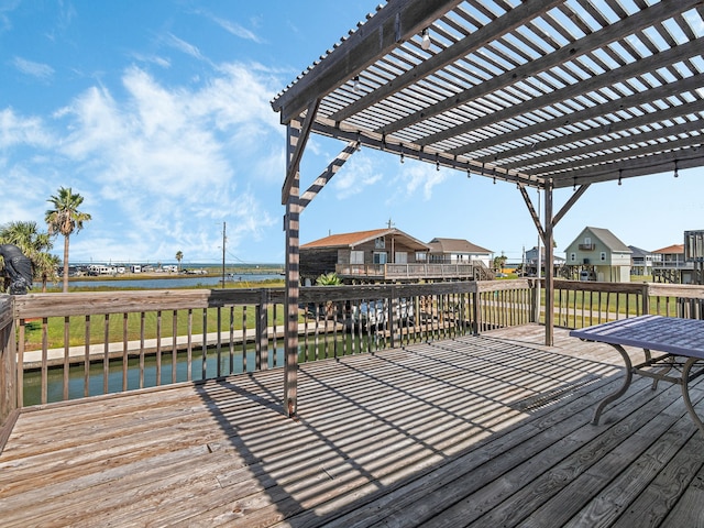 wooden deck with a water view and a pergola