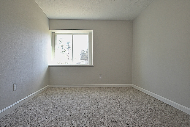 carpeted spare room featuring a textured ceiling