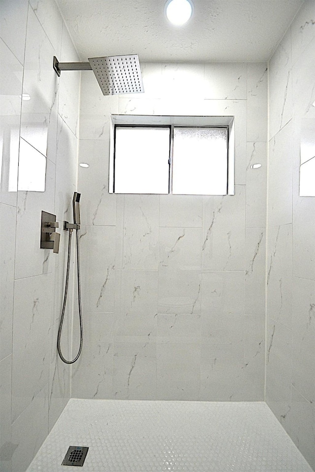 bathroom featuring a tile shower and plenty of natural light