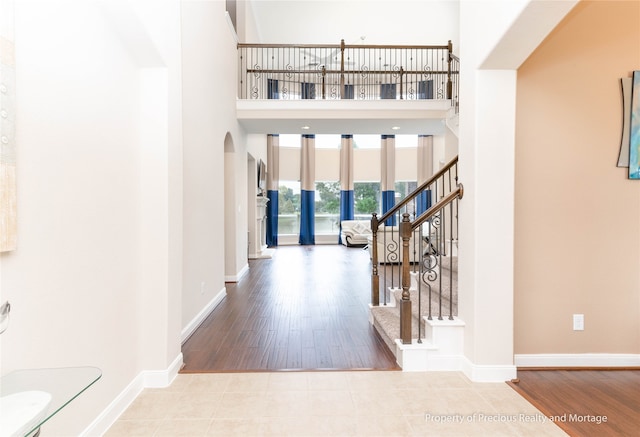 foyer featuring a towering ceiling and light hardwood / wood-style floors