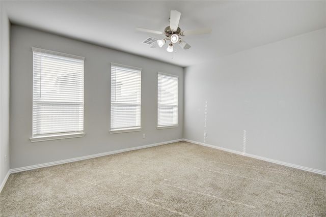 empty room with ceiling fan, plenty of natural light, and light carpet