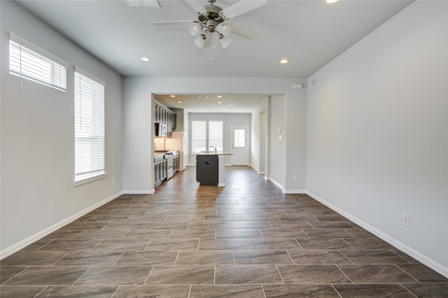 unfurnished living room with ceiling fan