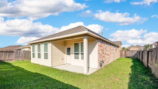 back of property featuring a yard and a patio