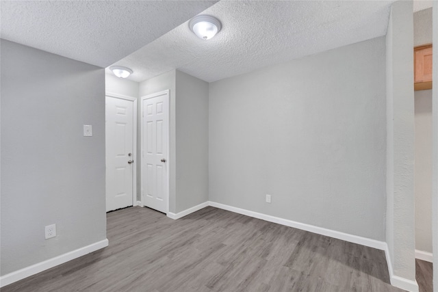 unfurnished room featuring hardwood / wood-style flooring and a textured ceiling