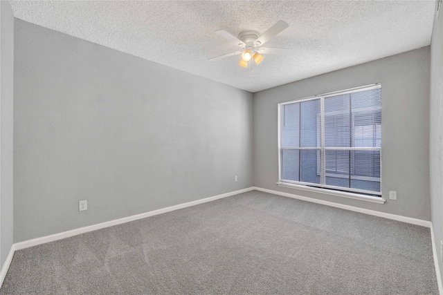 carpeted spare room featuring ceiling fan and a textured ceiling