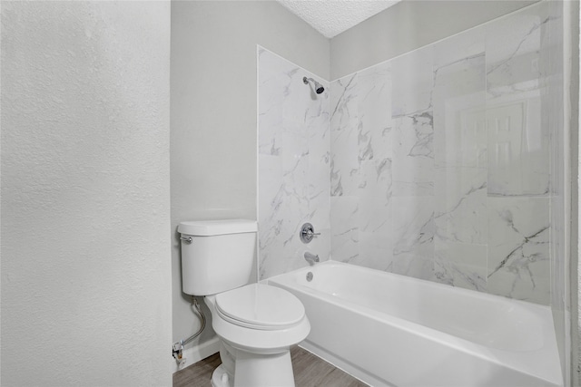 bathroom featuring hardwood / wood-style floors, tiled shower / bath, a textured ceiling, and toilet