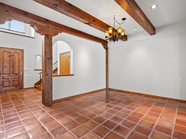 foyer with beam ceiling, tile patterned flooring, and a chandelier