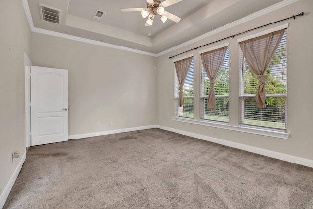 carpeted empty room featuring ceiling fan, a raised ceiling, and ornamental molding