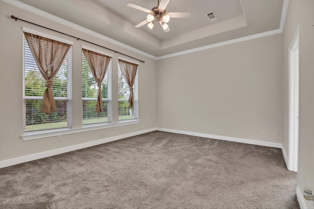 carpeted empty room with ornamental molding, ceiling fan, and a raised ceiling