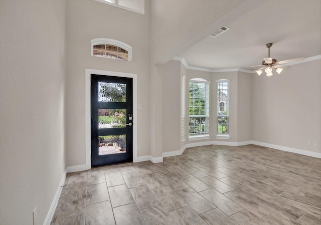 entrance foyer with ceiling fan, plenty of natural light, and crown molding