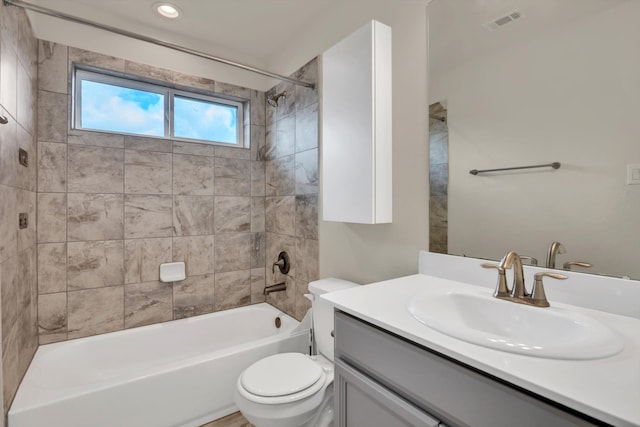 full bathroom with tiled shower / bath combo, vanity, and toilet