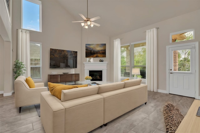 tiled living room featuring ceiling fan and high vaulted ceiling