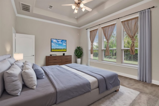 carpeted bedroom with ornamental molding, a tray ceiling, multiple windows, and ceiling fan