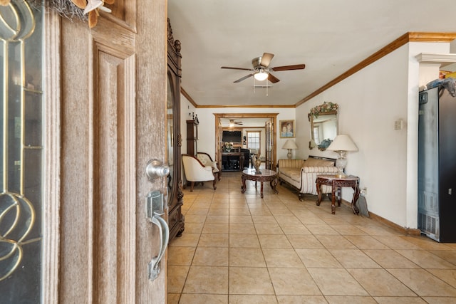 foyer with ornamental molding, ceiling fan, and light tile patterned floors