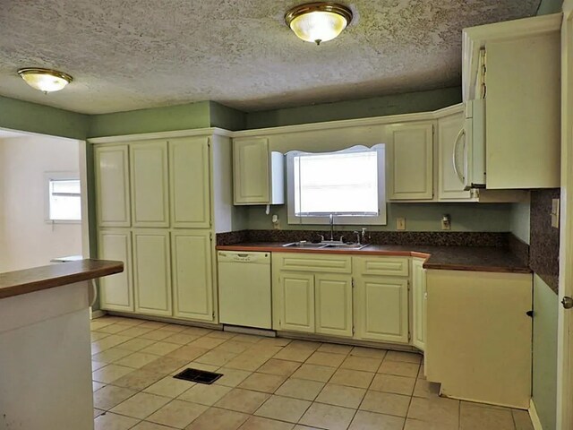 kitchen featuring light tile patterned flooring, a healthy amount of sunlight, white appliances, and sink