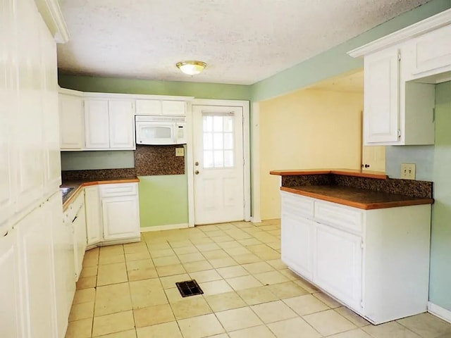 kitchen featuring light tile patterned flooring and white cabinetry