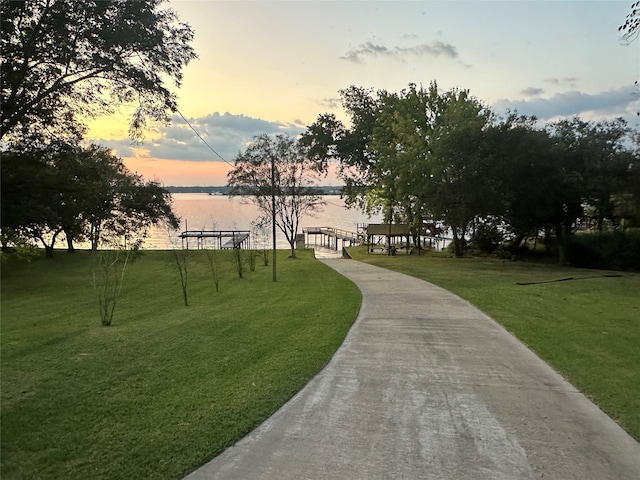 view of home's community with a water view and a yard