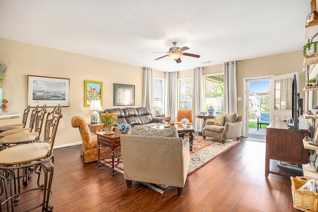 living room featuring ceiling fan and dark wood-type flooring