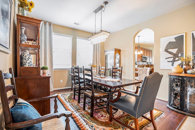 dining room featuring hardwood / wood-style flooring, plenty of natural light, and a chandelier