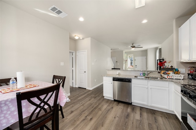 kitchen featuring light stone counters, hardwood / wood-style flooring, sink, white cabinets, and stainless steel appliances