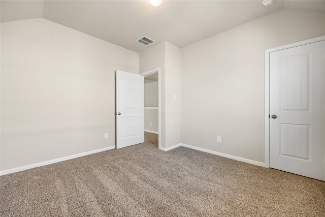 unfurnished bedroom with lofted ceiling and carpet flooring