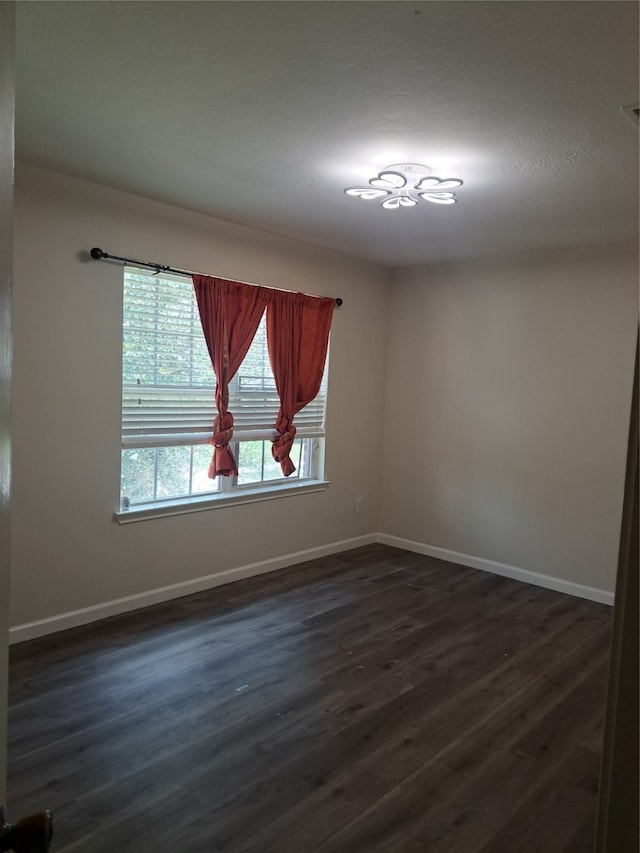 unfurnished room with dark wood-type flooring