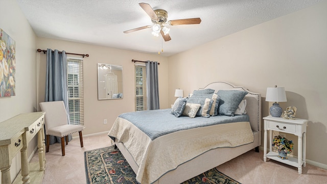 bedroom with ceiling fan, a textured ceiling, and light carpet