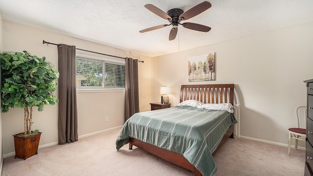 carpeted bedroom with ceiling fan and a textured ceiling