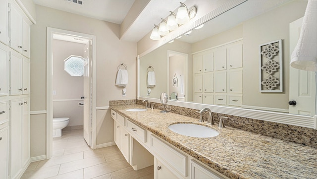 bathroom featuring tile patterned flooring, vanity, and toilet