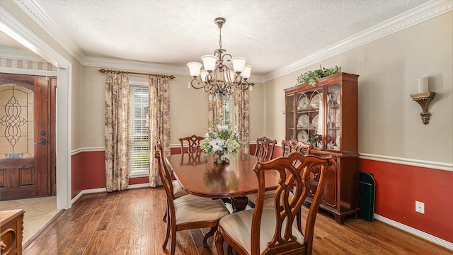 dining room with ornamental molding, a textured ceiling, plenty of natural light, and hardwood / wood-style floors