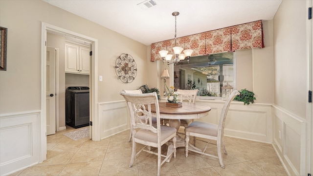 tiled dining space featuring an inviting chandelier