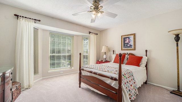 carpeted bedroom featuring ceiling fan and a textured ceiling