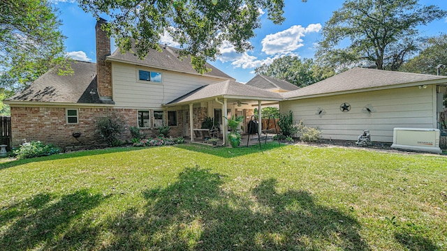 back of property with a patio and a yard