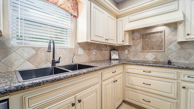 kitchen with cream cabinetry, sink, and decorative backsplash