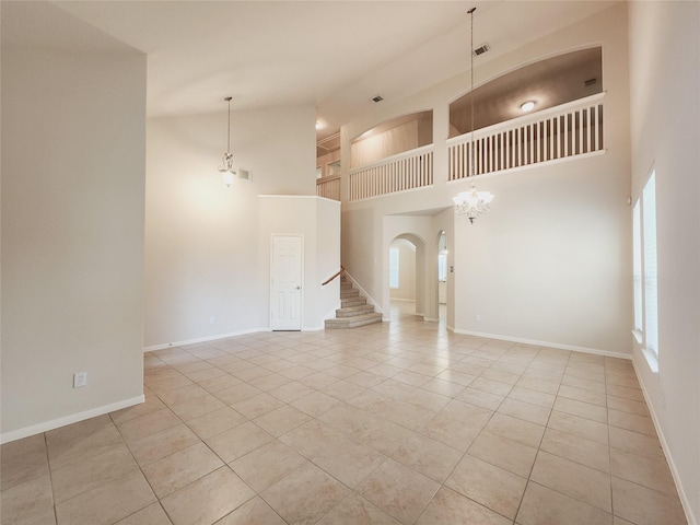 unfurnished living room with a towering ceiling and light tile patterned flooring