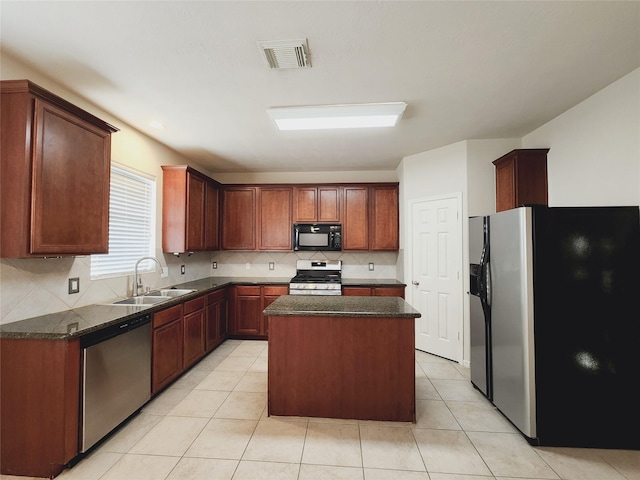 kitchen featuring a center island, light tile patterned flooring, sink, and appliances with stainless steel finishes