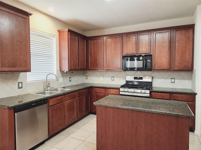 kitchen featuring a kitchen island, light tile patterned floors, sink, and appliances with stainless steel finishes