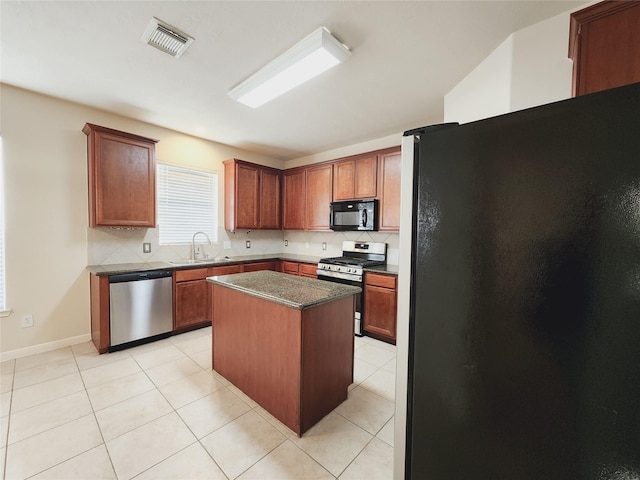 kitchen featuring a center island, light tile patterned flooring, black appliances, and sink