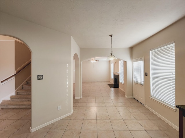 hall featuring plenty of natural light and light tile patterned floors