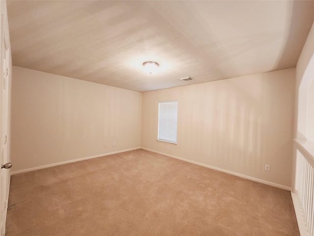 empty room featuring light carpet and a textured ceiling